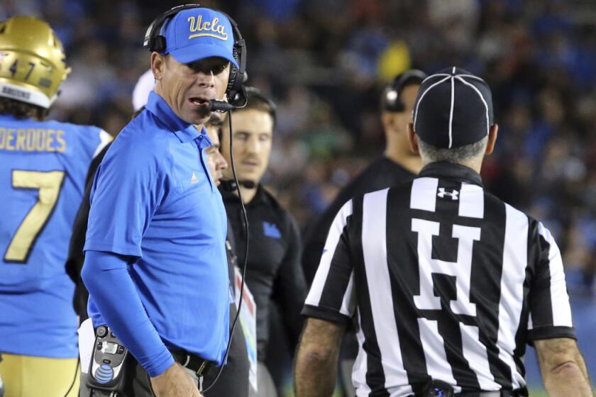 UCLA Coach Jim Mora, who was penalized 15 yards during the first quarter of Saturday's game, displays a calmer side in the second half.