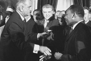 FILE - President Lyndon B. Johnson shakes hands with Martin Luther King Jr., after presenting a pen to the civil rights leader after Johnson signed the voting rights bill at the Capitol in Washington, Aug. 6, 1965. At center is Rep. Ray Madden, D-Ind. Joel Finkelstein was an accidental witness to one of the seminal events during the Civil Rights Movement, the signing in 1965 of the Voting Rights Act. He was a year out of law school when he received the call to head to the U.S. Capitol for the signing. He had helped write the law as a lawyer in the Justice Department's Civil Rights Division. (AP Photo)