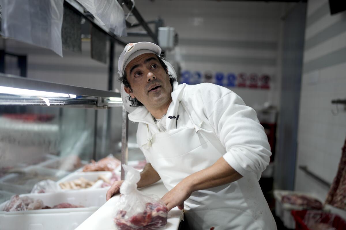 El carnicero Mario Giménez corta carne en la carnicería donde trabaja 