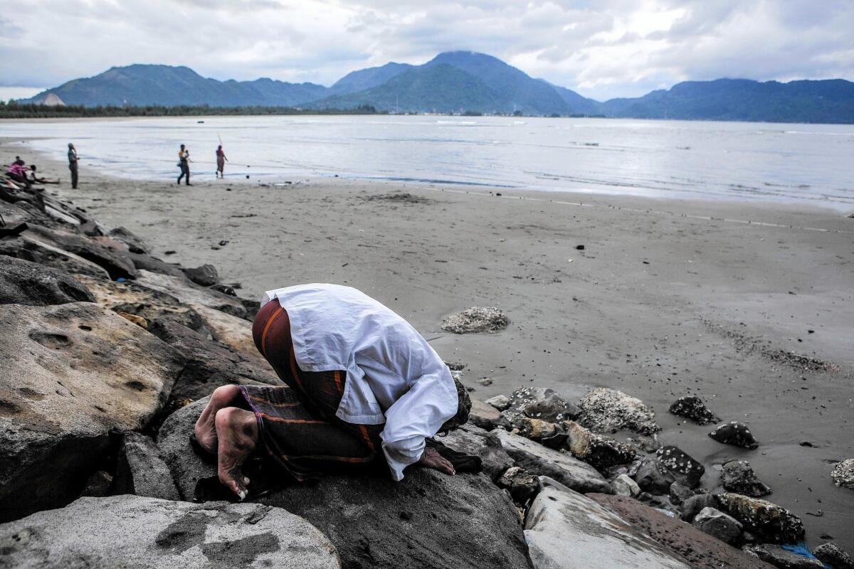 A fisherman prays on the beach in Banda Aceh, Indonesia.