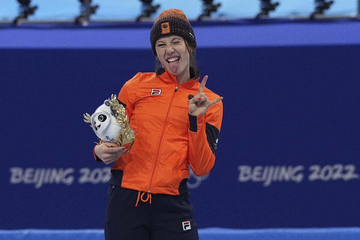 Suzanne Schulting of the Netherlands celebrates on the podium after winning gold in the women's 1,000-meters short track