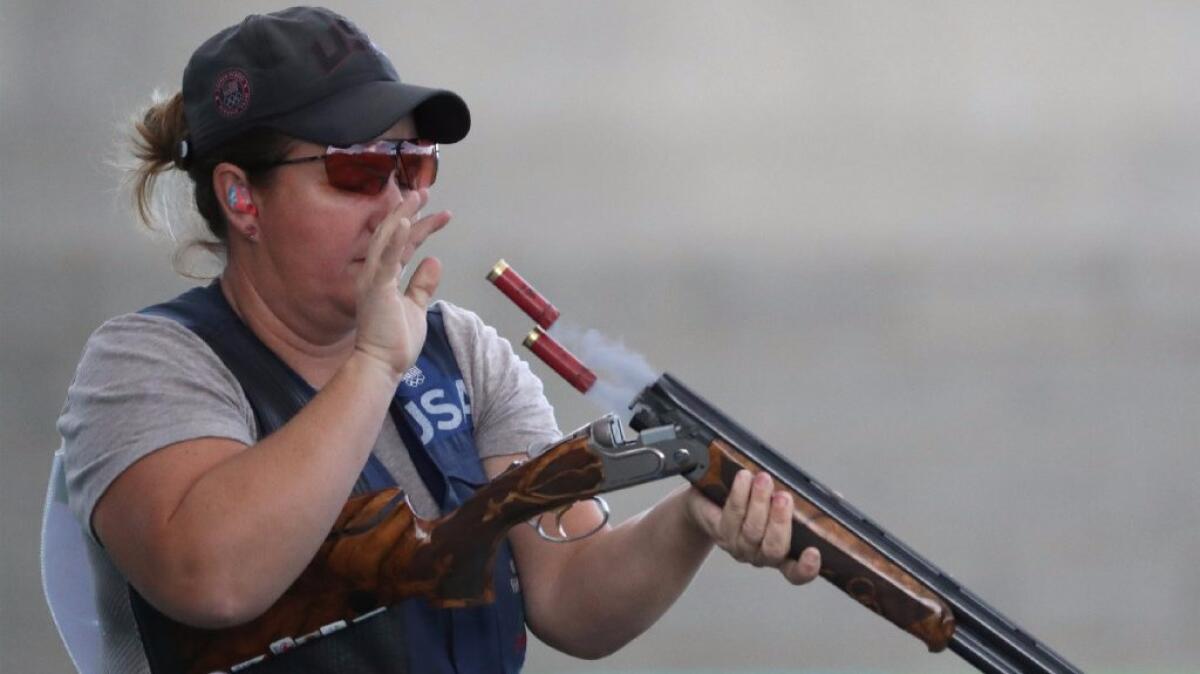 Kim Rhode discards spent shotgun shells as she competes during the bronze-medal match in women's skeet at Olympic Shooting Park on Aug. 12.