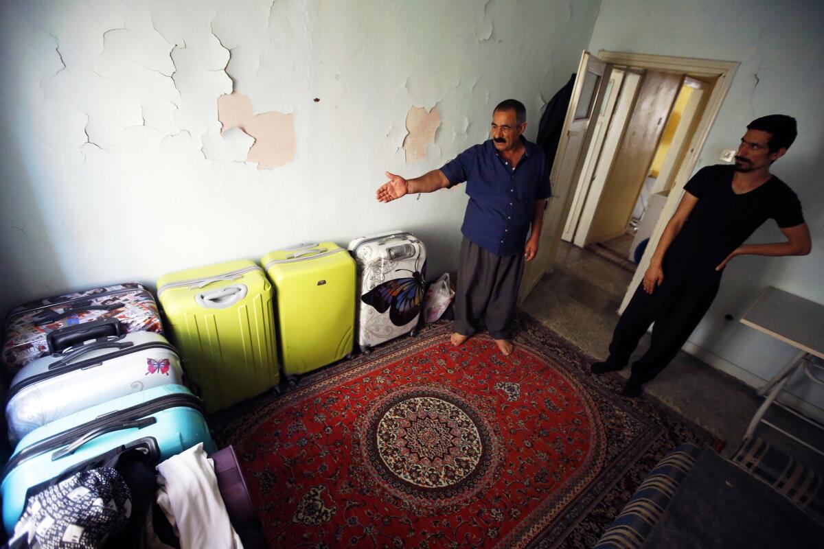 In 2017, Seid Moradi and his son Sirvan with the family's suitcases, still packed after their flights from Turkey to the U.S. were canceled.