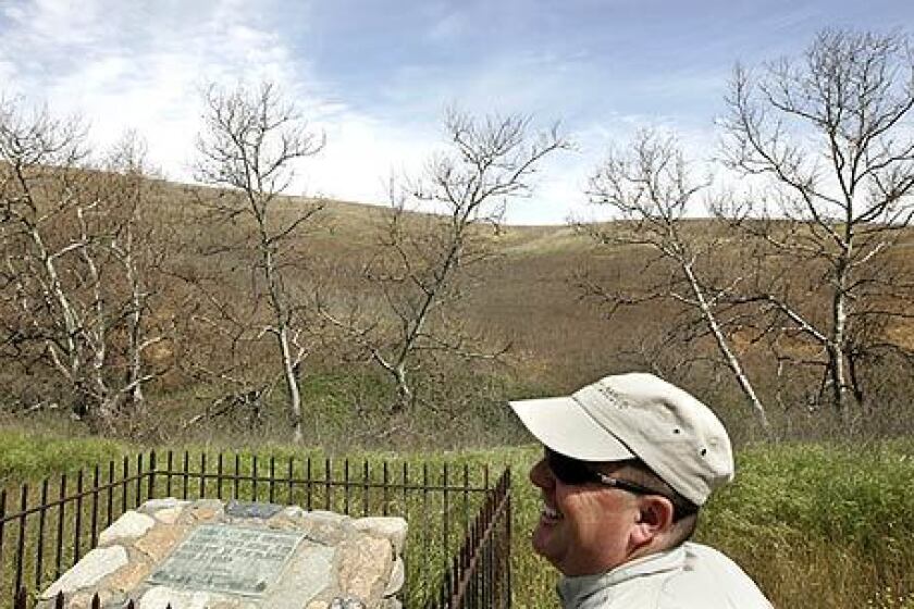 Dave Raetz, director of public programs with the Irvine Ranch Conservancy, stands near the Hangman's Tree and monument, which sits about 100 yards from the Foothill Toll Road.