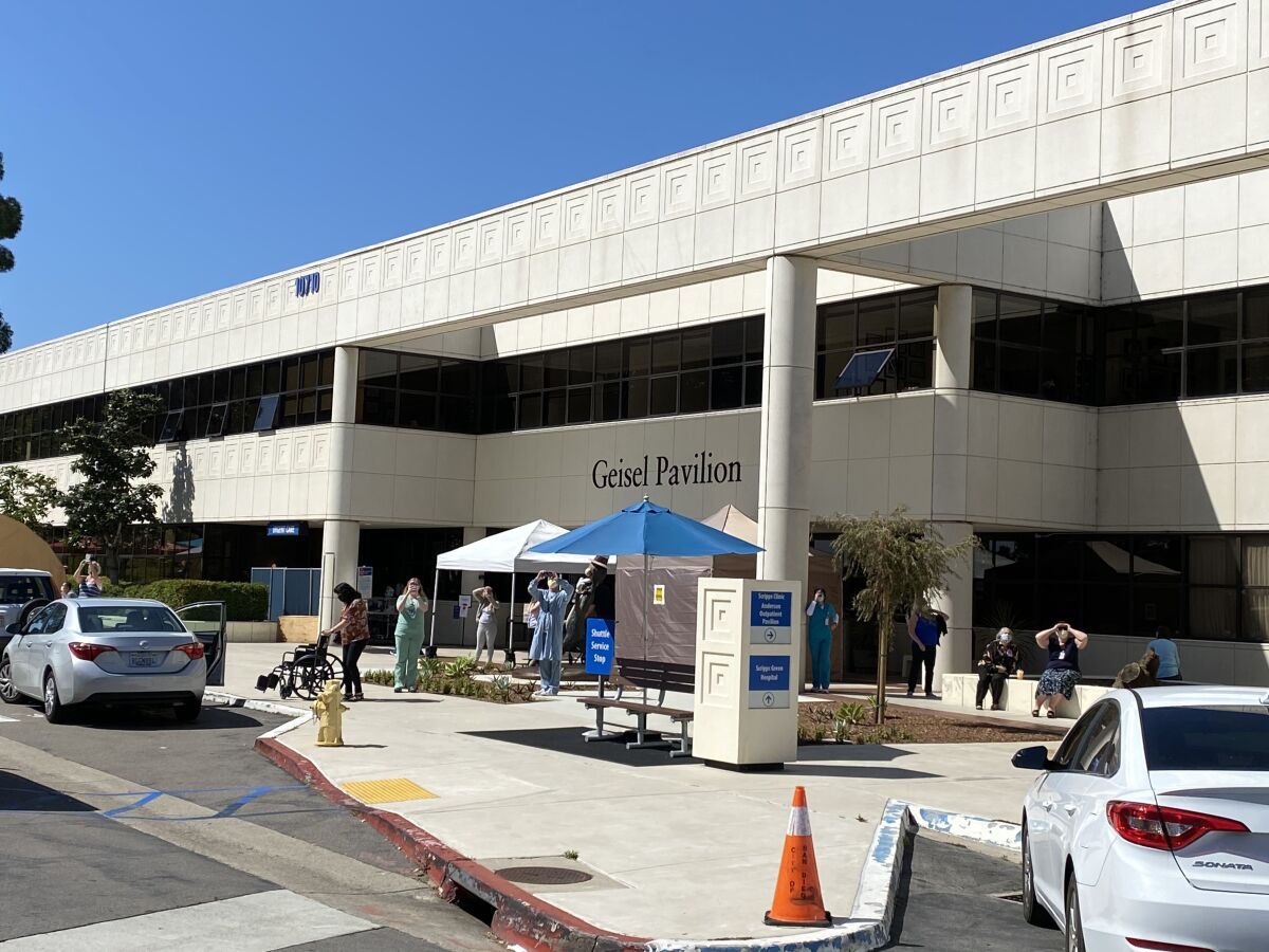 Medical professionals gather outside Scripps Green Hospital in La Jolla to watch a fly-over by private pilots as a thank-you for their work against the coronavirus.