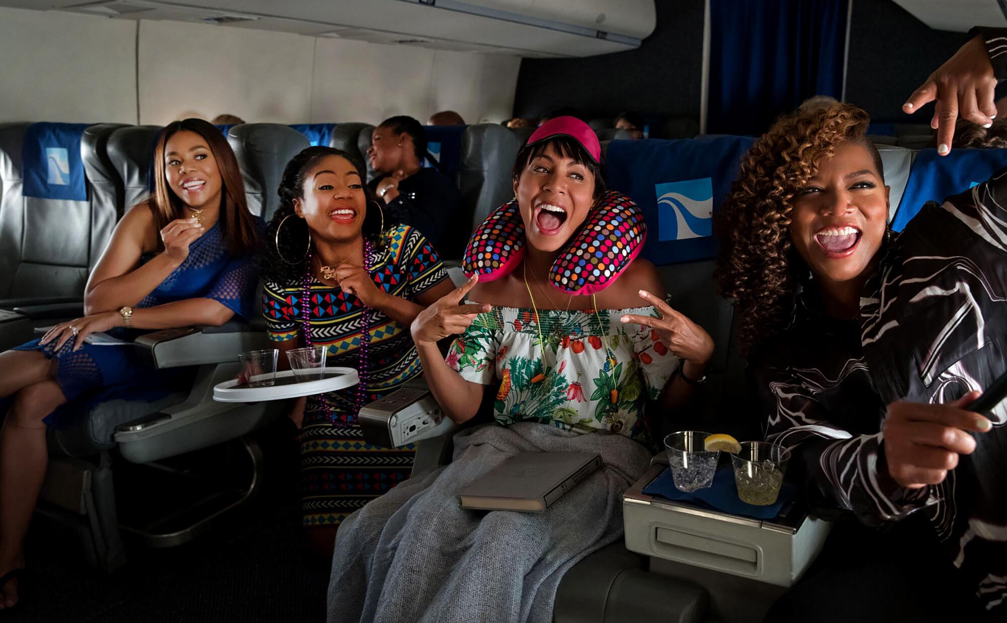 Four women excited to be traveling on an airplane