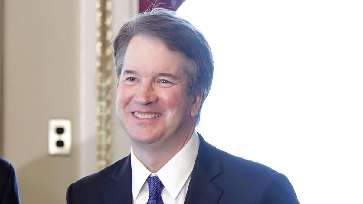 Judge Brett Kavanaugh poses for photographs before meeting with lawmakers at the Capitol on Wednesday.