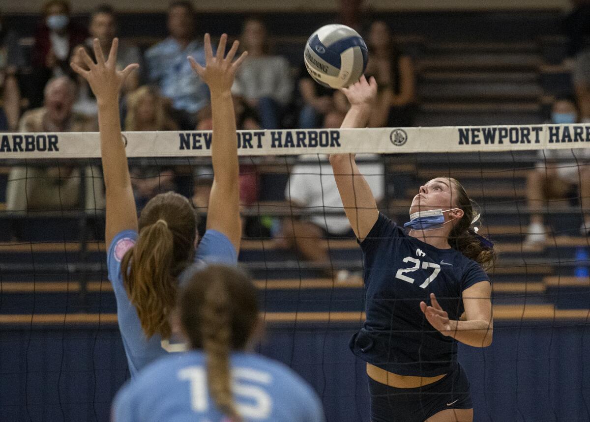 Newport Harbor's Emma Fults hits against Corona del Mar's Ava Axelson during the Battle of the Bay girls' volleyball match.