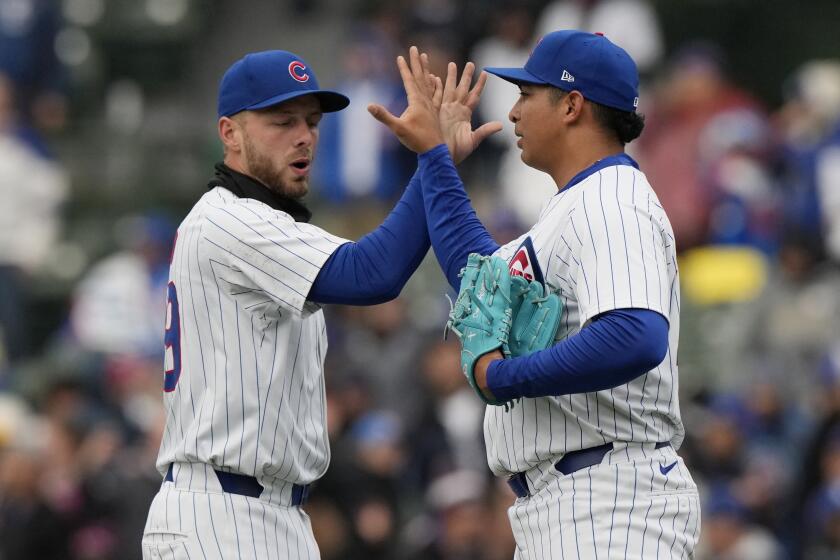 Michael Busch, de los Cachorros de Chicago, a la izquierda, celebra con el relevista Daniel Palencia después de que los Cachorros derrotaron 8-1 a los Dodgers de Los Ángeles en un juego de béisbol en Chicago, el domingo 7 de abril de 2024. (AP Foto/Nam Y. Huh)