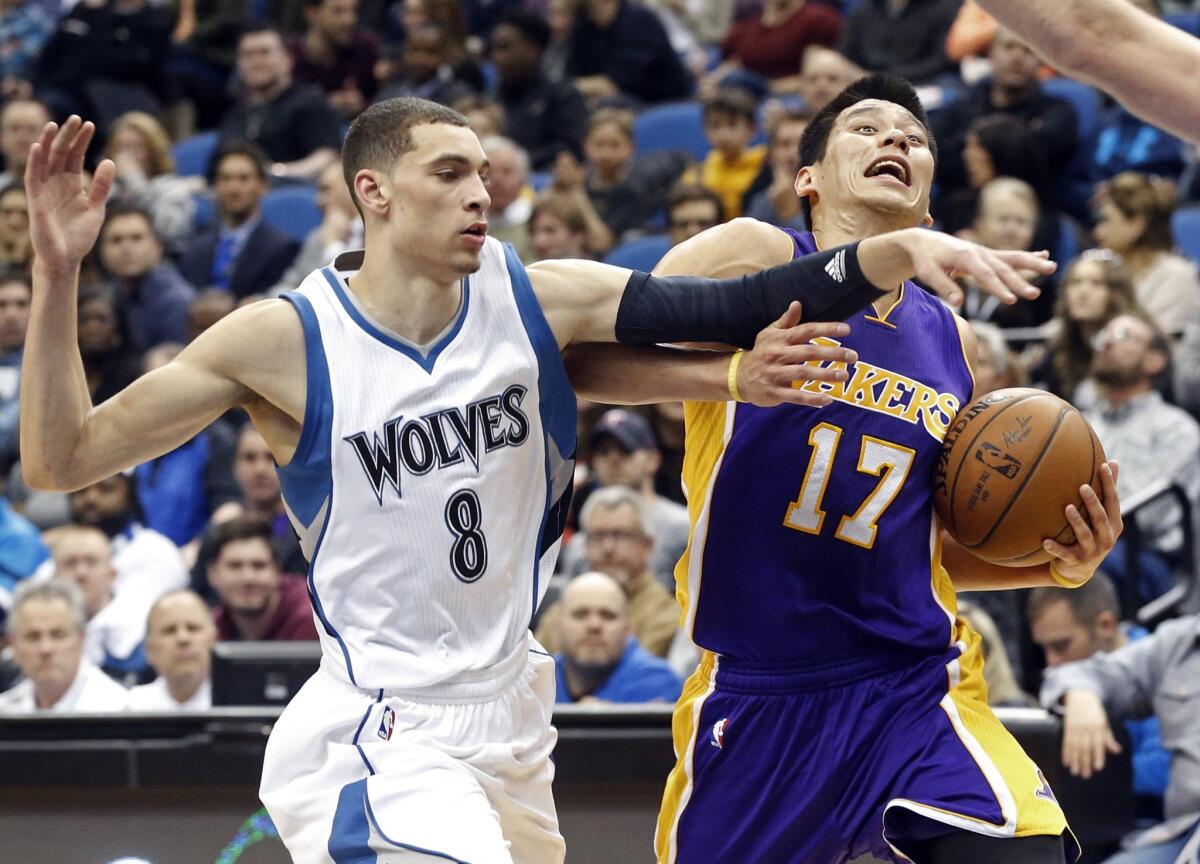Lakers point guard Jeremy Lin takes an elbow from Timberwolves guard Zach LaVine as he drives to the basket in the second half.