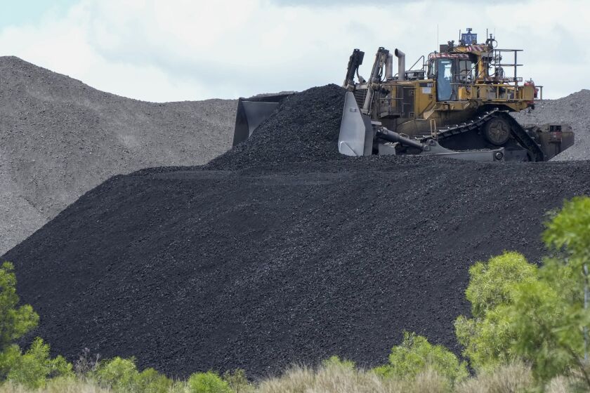 Heavy machinery moves coal as it is poured onto a stack near Muswellbrook in the Hunter Valley, Australia, Nov. 2, 2021. The Australian government, Thursday, Feb. 9, 2023, has for the first time rejected a coal mining application based on environmental law.(AP Photo/Mark Baker)
