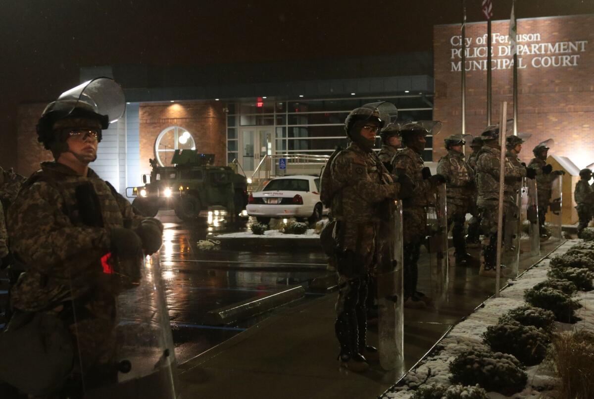 Missouri National Guard troops stand in the rain outside the Ferguson Police Station on Nov. 26.