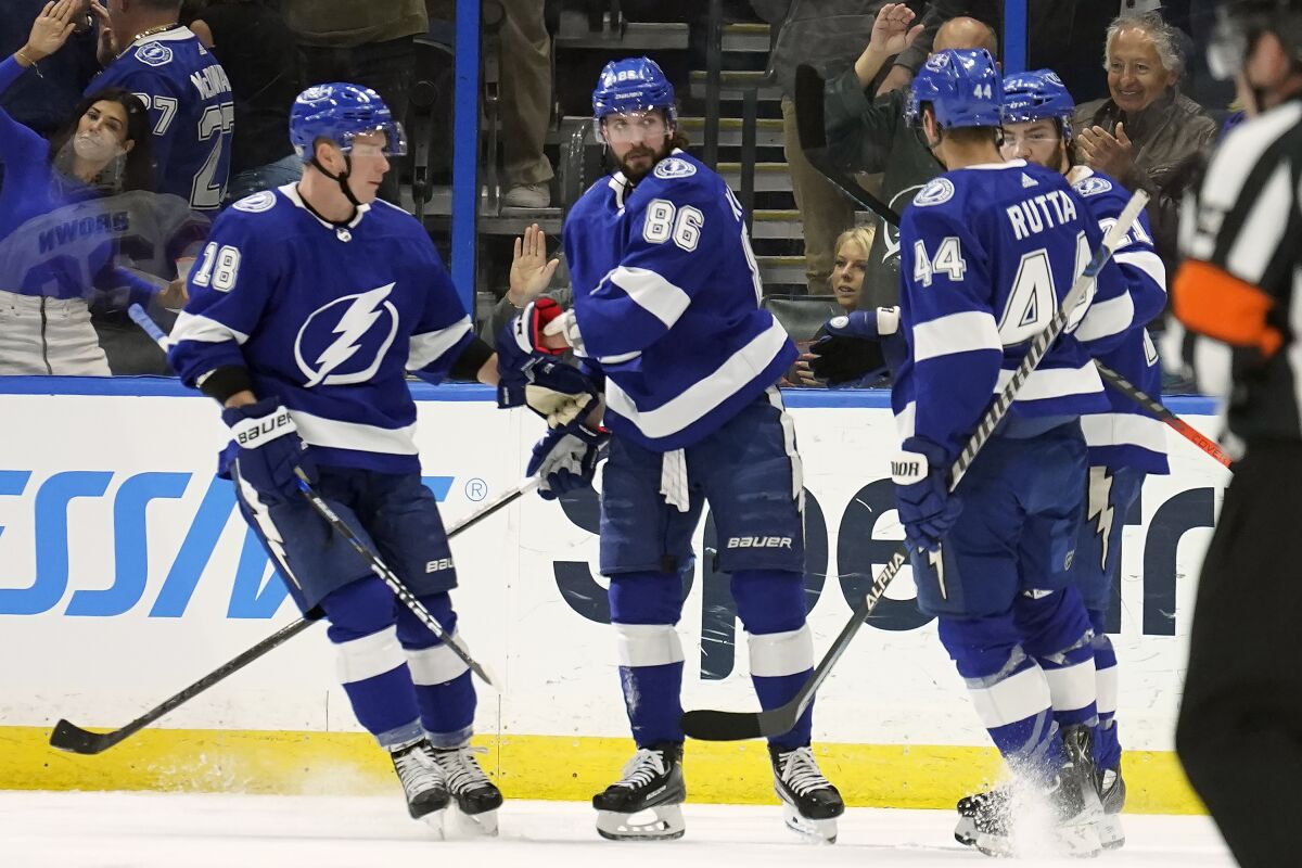 Tampa Bay Lightning right wing Nikita Kucherov (86) celebrates with left wing Ondrej Palat (18) and defenseman Jan Rutta (44) after scoring against the Ottawa Senators during the first period of an NHL hockey game Tuesday, March 1, 2022, in Tampa, Fla. (AP Photo/Chris O'Meara)