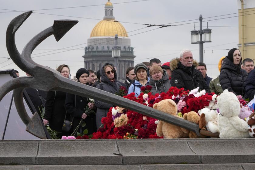 People lay flowers at a spontaneous memorial in memory of the victims of Moscow attack in St. Petersburg, Russia, Sunday, March 24, 2024. Russia observed a national day of mourning on Sunday, two days after an attack on a suburban Moscow concert hall that killed over 130 people. (AP Photo/Dmitri Lovetsky)