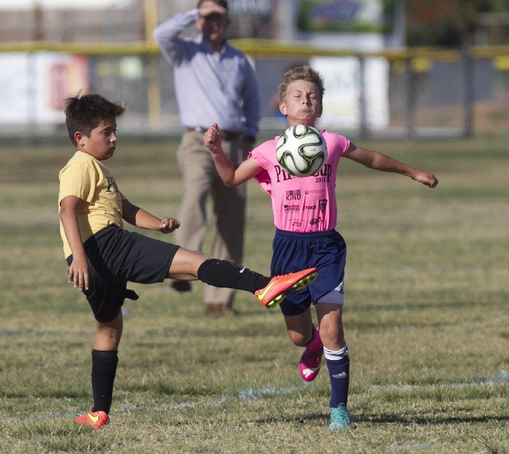 St. Joachim's Jackson Young, in pink, controls the ball and runs upfield in a hurry.
