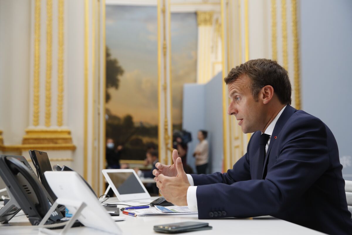 French President Emmanuel Macron speaks with the head of the World Health Organization and other leaders.