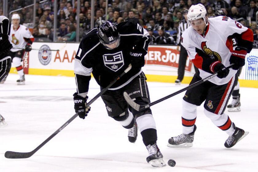 Kings right wing Matt Frattin battles Senators right wing Bobby Ryan for the puck during the first period of a game last week at Staples Center.