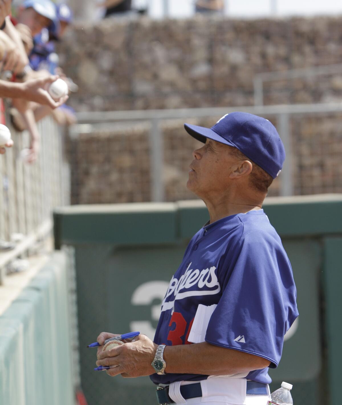 Maury Wills signs baseballs for fans.