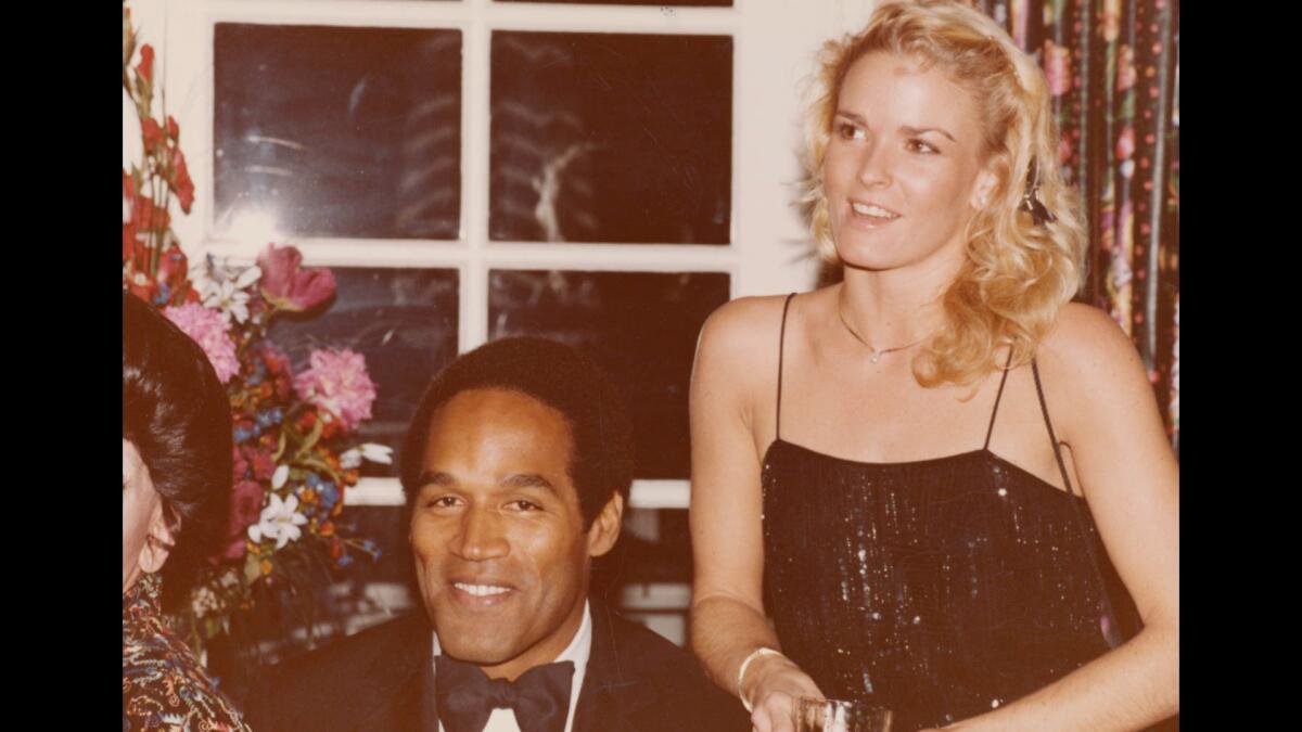 A photograph of O.J. and Nicole Brown Simpson standing next to each other near a window.