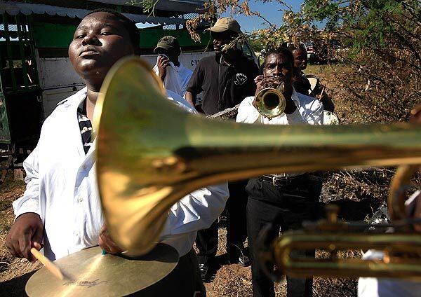 A small brass band plays while the dead are buried in a mass grave in Titanyen, outside Port-au-Prince, Haiti.