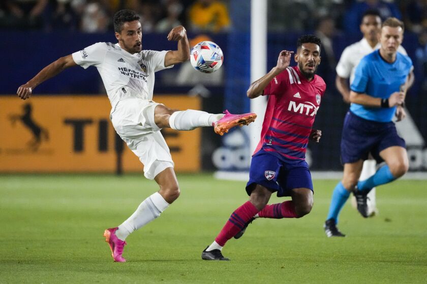 Los Angeles Galaxy midfielder Sebastian Lletget, left, kicks the ball during the first half of an MLS soccer game against the FC Dallas Wednesday, July 7, 2021, in Carson, Calif. FC Dallas forward Jesus Ferreira (9) is second from right. (AP Photo/Ashley Landis)