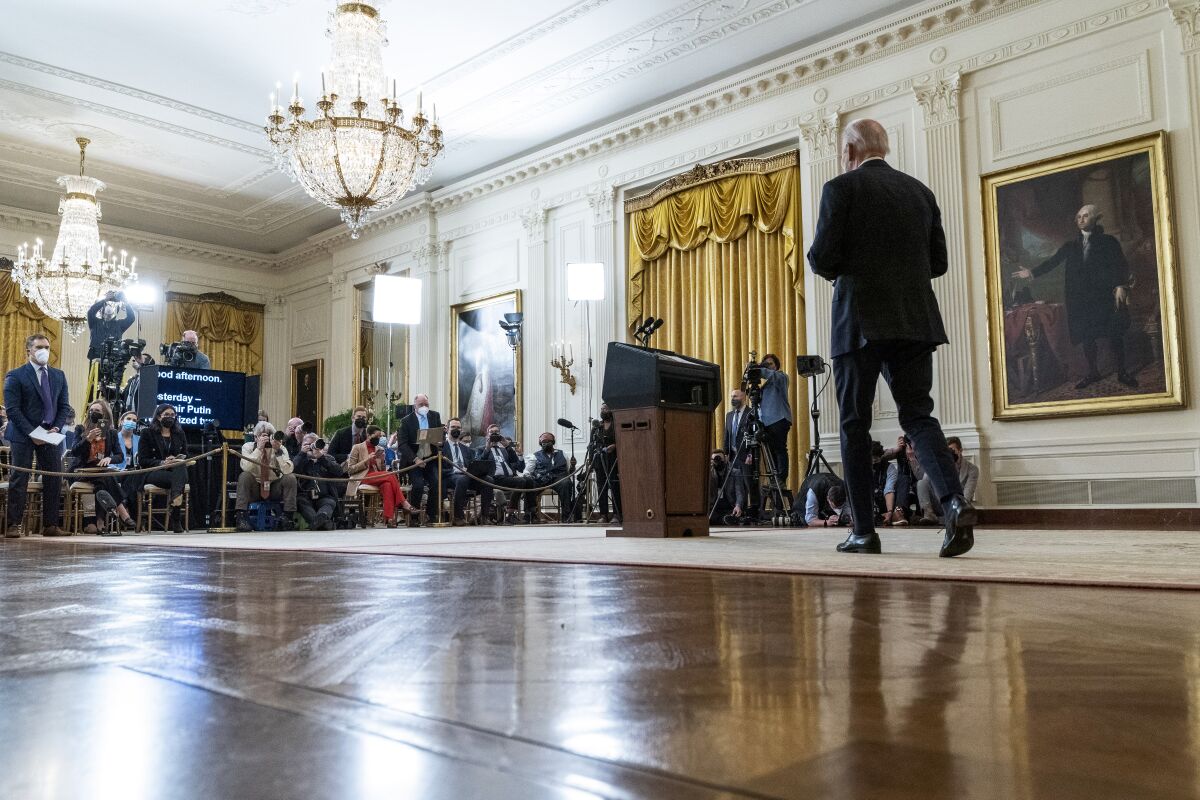 President Biden walks toward a group of reporters.