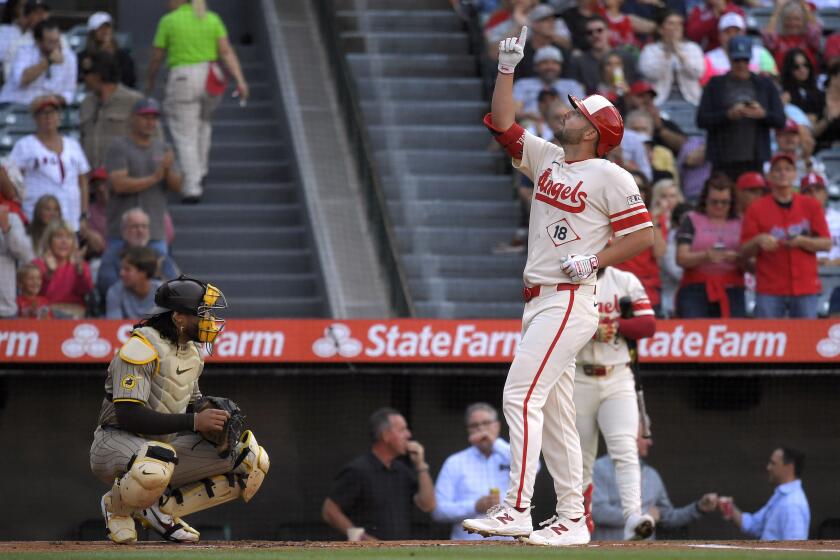 Los Angeles Angels' Nolan Schanuel, right, gestures as he scores after hitting a solo home run as San Diego Padres catcher Luis Campusano watches during the first inning of a baseball game Wednesday, June 5, 2024, in Anaheim, Calif. (AP Photo/Mark J. Terrill)