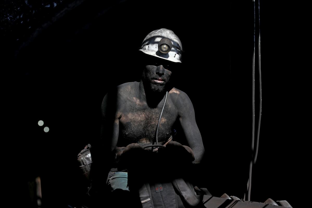A miner comes to the surface after mining for coal at Mexico's Santa Barbara mine.