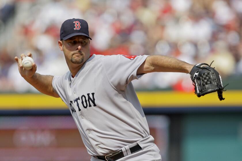 FILE - Boston Red Sox starter Tim Wakefield works in the second inning of a baseball game against the Atlanta Braves in Atlanta, June 27, 2009. Wakefield, the knuckleballing workhorse of the Red Sox pitching staff who bounced back after giving up a season-ending home run to the Yankees in the 2003 playoffs to help Boston win its curse-busting World Series title the following year, has died. He was 57. The Red Sox announced his death in a statement Sunday, Oct. 1 2023, (AP Photo/John Bazemore file)