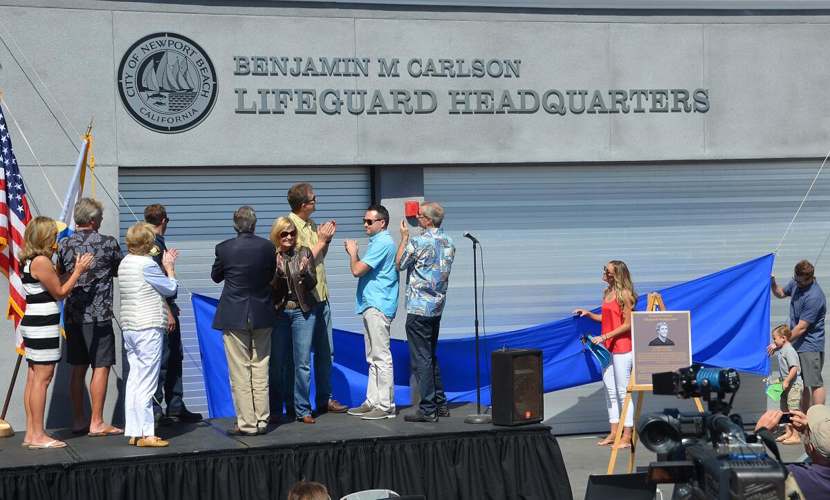 The family of Ben Carlson is joined by Newport Beach city leaders during the renaming of the city's lifeguard headquarters.