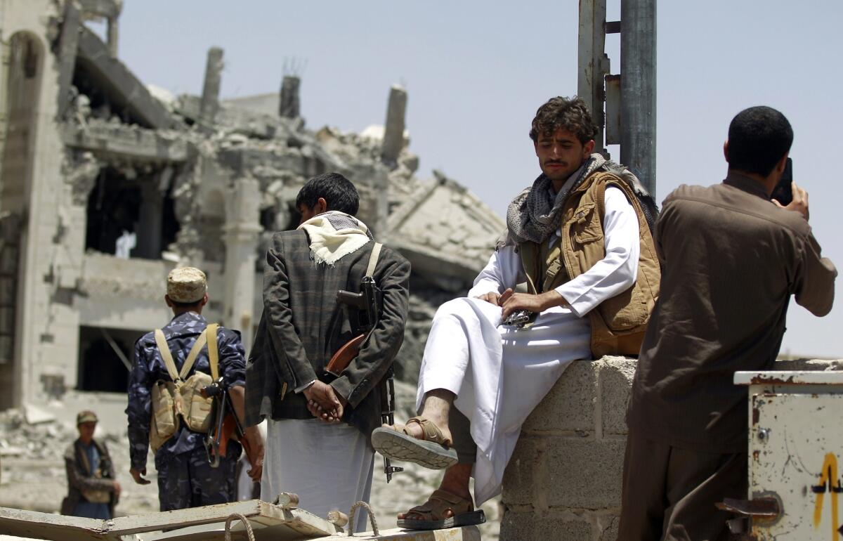 Houthi rebels look at the damage in the yard of the residence of their military commander after an airstrike destroyed the property in the Yemeni capital, Sana, on April 28.