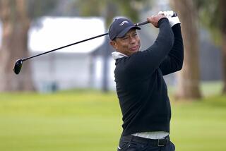 Tiger Woods hits his approach shot on the 11th hole.