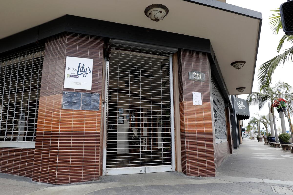 The security gates are shuttered at Balboa Lily's near the Balboa Pier in Newport Beach at midday Thursday.