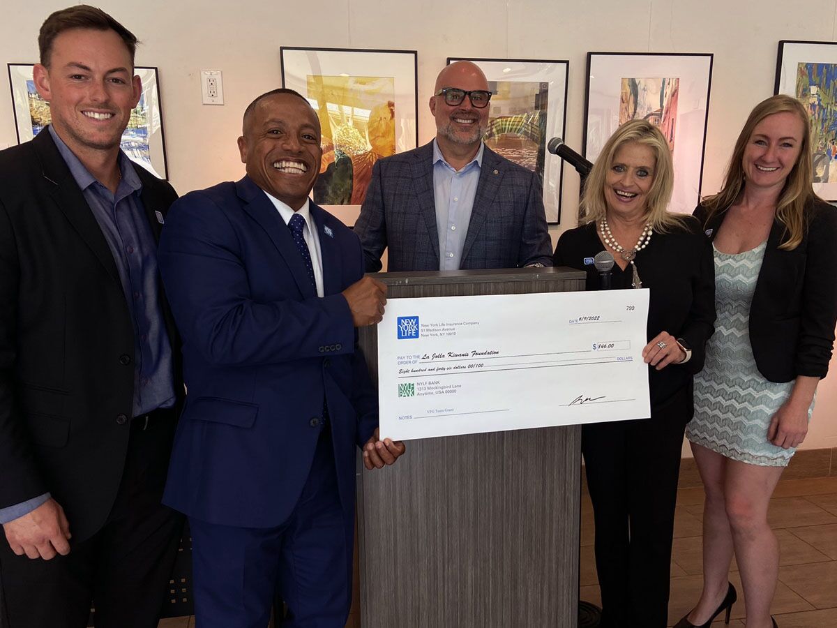 Kiwanis Club of La Jolla President Craig Gagliardi (center) receives a check from New York Life.