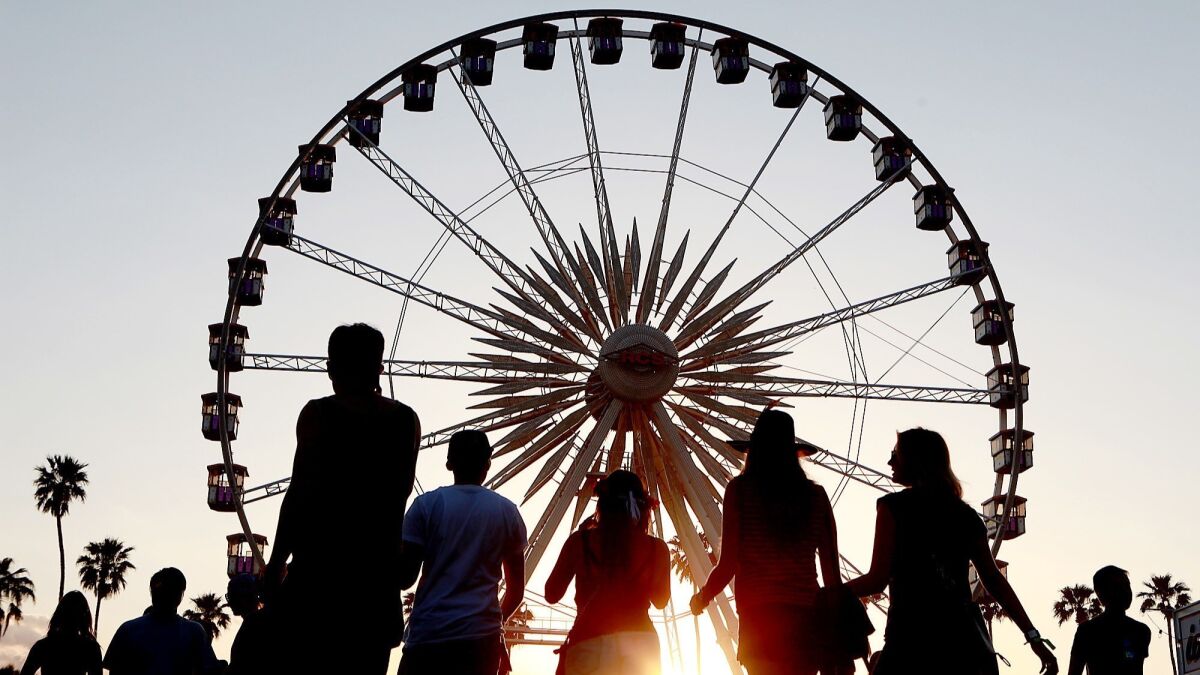 The sun sets on festival goers and the ferris wheel at the Coachella Music & Arts Festival