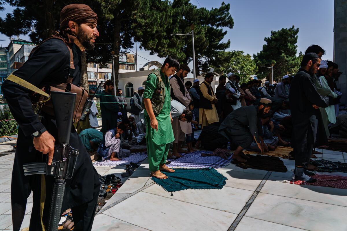 Taliban fighters set down prayer mats during Friday prayers 