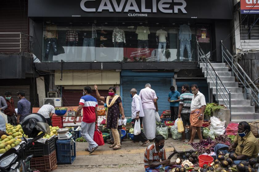 People wearing masks as precaution against the coronavirus shop for vegetables at a Sunday market in Kochi, Kerala state, India, Sunday, April 18, 2021. (AP Photo/R S Iyer)