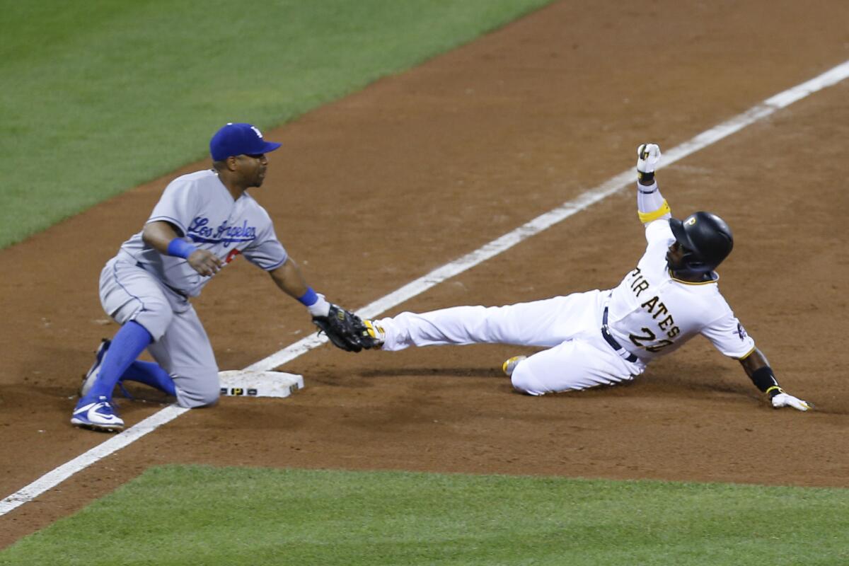 Dodgers third baseman Alberto Callaspo puts a tag on Pittsburgh's Andrew McCutchen as he tries to take third on a wild pitch during a game on Aug. 7.