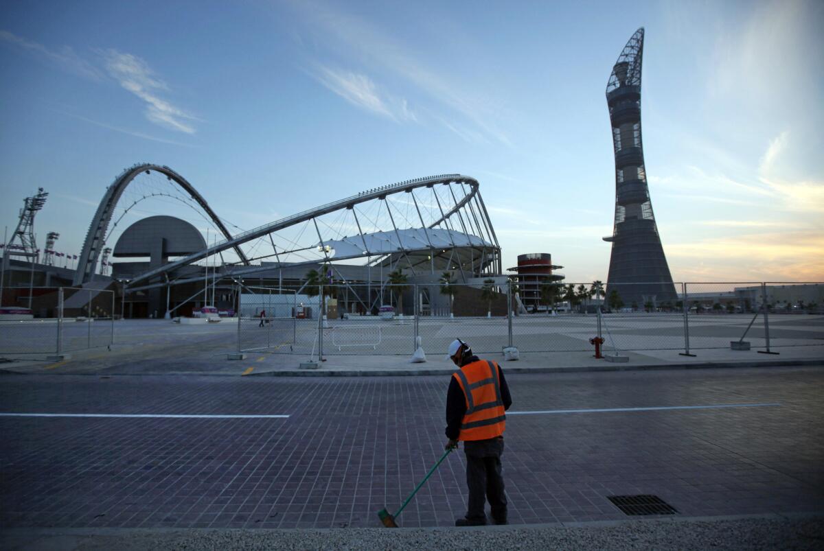 A worker cleans the road outside Khalifa sports complex in 2011 in Doha, Qatar, where the men's World Cup final will be held in 2022.