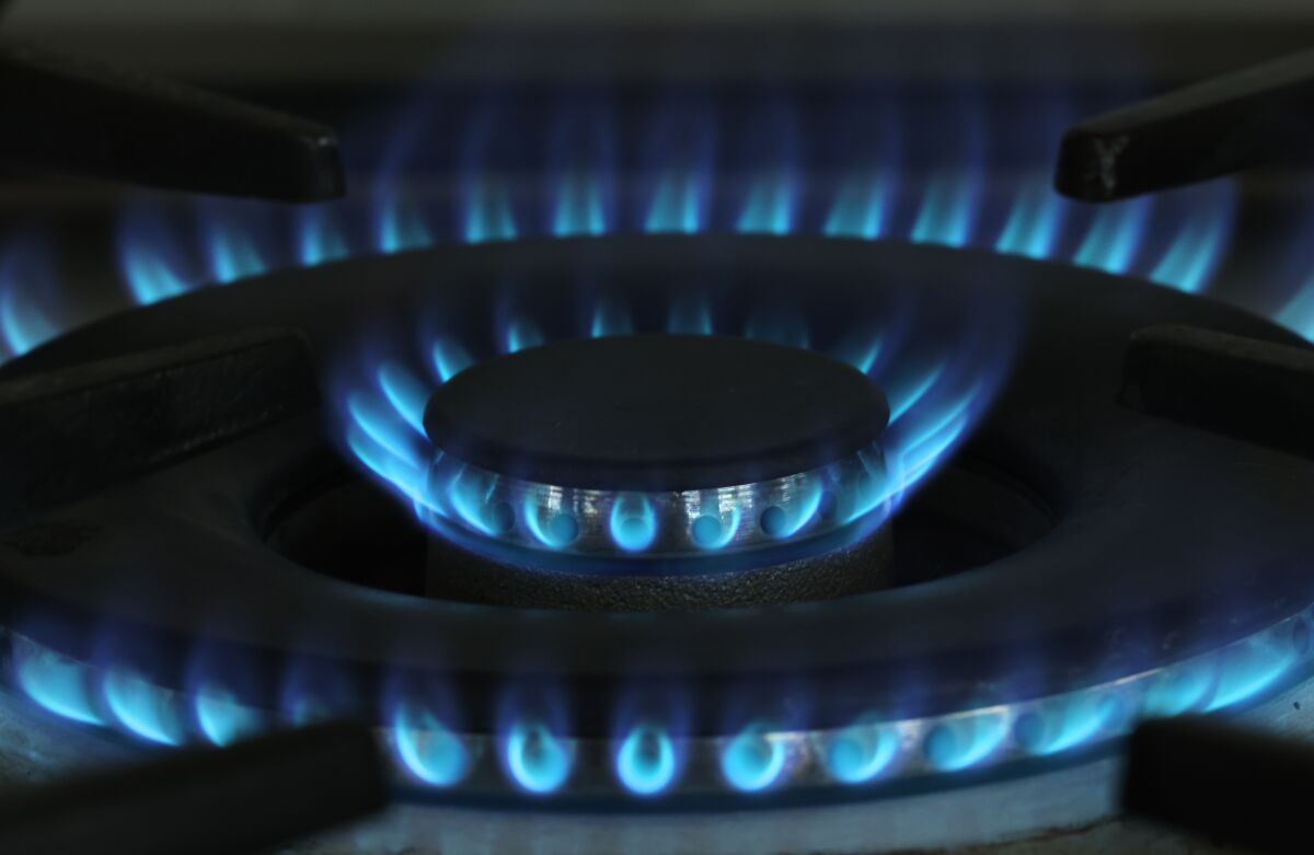 A gas flame burns on a stove top  