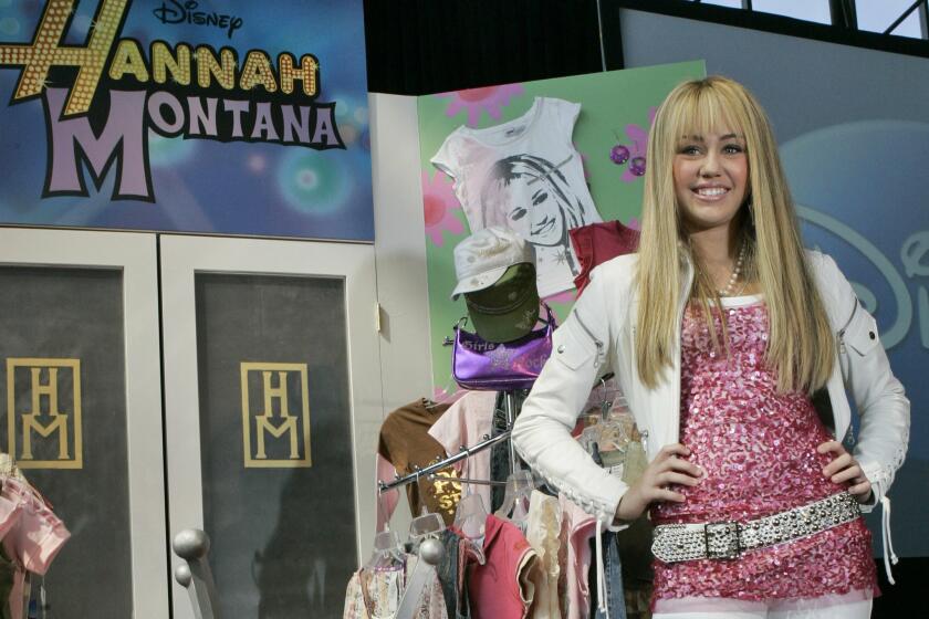 FILE - In this June 19, 2007 file photo Miley Cyrus, star of The Disney Channel's series "Hannah Montana" makes an appearance at the Licensing International Expo in New York. Costumes, props and tour items from the Disney Channel’s “Hannah Montana” TV series are going up for auction. The teen sitcom featured Cyrus, who portrayed schoolgirl Miley Stewart by day and international pop star Hannah Montana by night. It helped launched Cyrus’ career and the franchise included albums, films and concerts. Julien’s Auctions announced on Thursday, April 11, 2019, all proceeds will benefit the Wilder Minds charity, which aids the world’s at-risk animals. (AP Photo/Mary Altaffer, File)