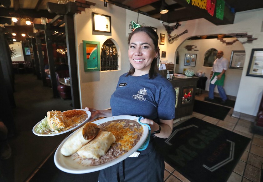 Server Mariela Valladares brings out dishes Thursday during a Cinco de Mayo celebration at Mi Casa Mexican restaurant.