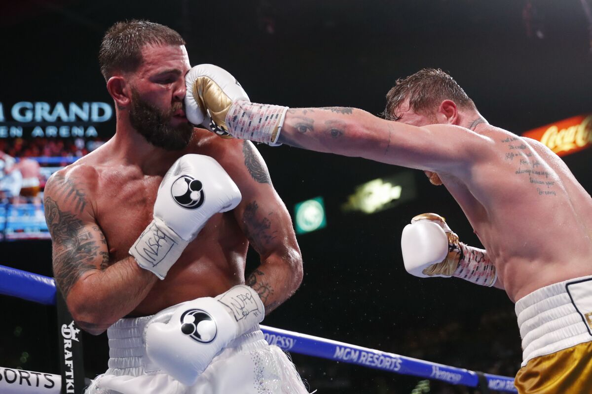 Canelo Álvarez lands a punch to Caleb Plant's head during their super middleweight title fight Saturday.
