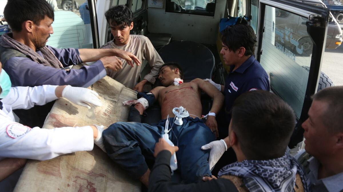 A man is helped into an ambulance after being injured in a deadly suicide bombing that targeted a training class in a private building in the Shiite neighborhood of Dasht-i Barcha, in western Kabul, Afghanistan, on Wednesday.