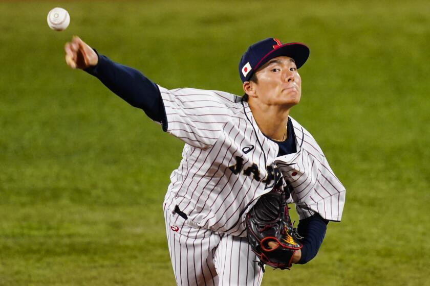 Japan's Yoshinobu Yamamoto pitches during the during a semi-final baseball game against South Korea.