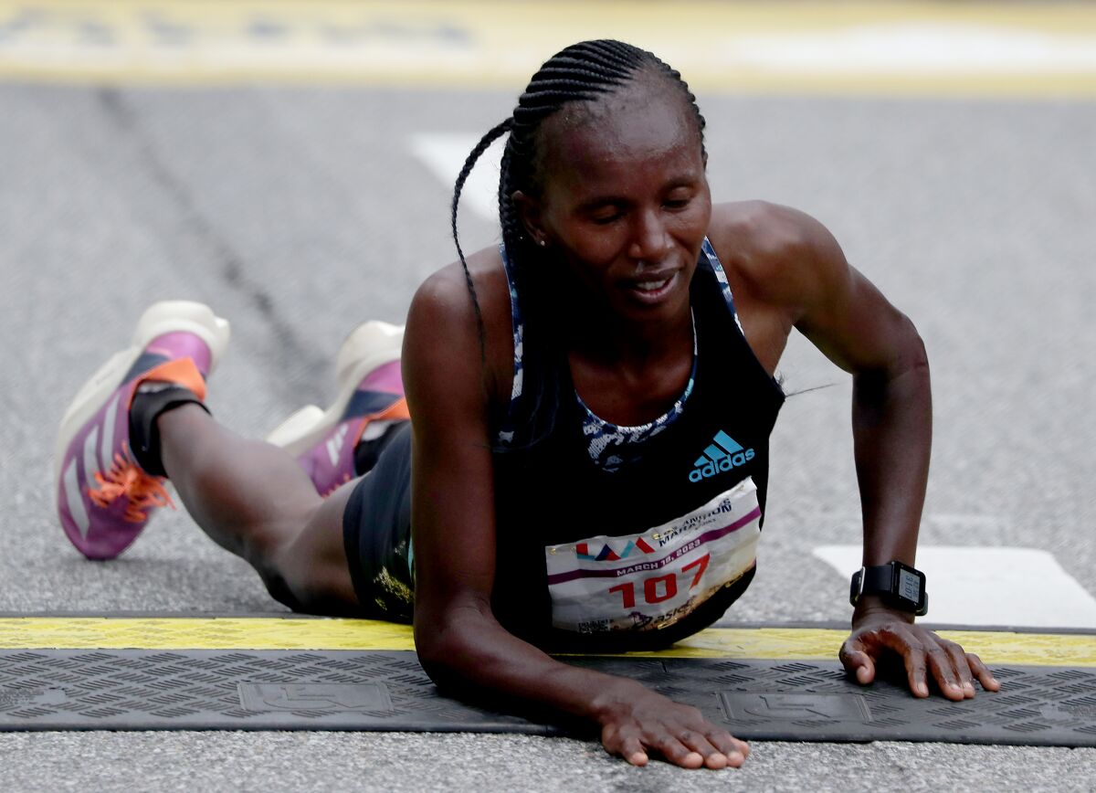 Runner Stacy Ndiwa on the ground at the L.A. Marathon finish line.