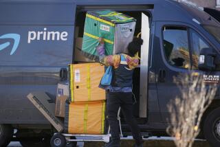 An Amazon Prime delivery person struggles with packages while making a stop at a high-rise apartment building on Tuesday, Nov. 28, 2023, in Denver. (AP Photo/David Zalubowski)
