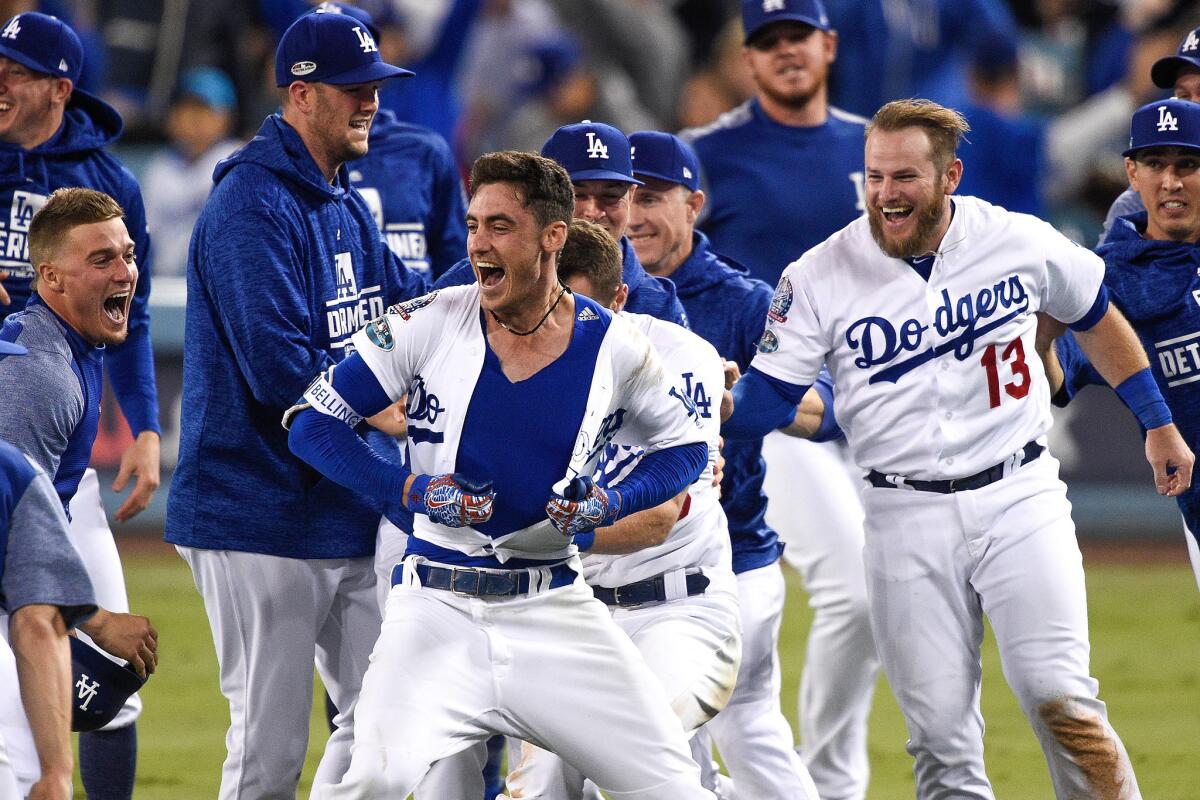 Cody Bellinger #35 of the Los Angeles Dodgers celebrates with teammates after hitting a walk-off single in the thirteenth inning against the Milwaukee Brewers to win Game Four of the National League Championship Series 2-1 at Dodger Stadium on October 16, 2018 in Los Angeles, California.