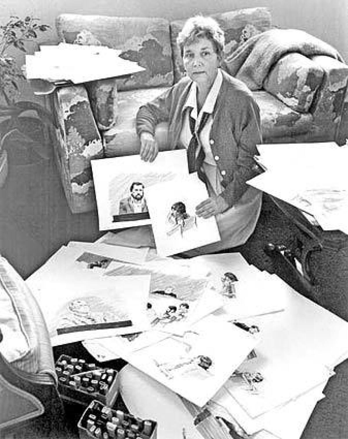 A photo of Mary Chaney holding some of her courtroom sketches.