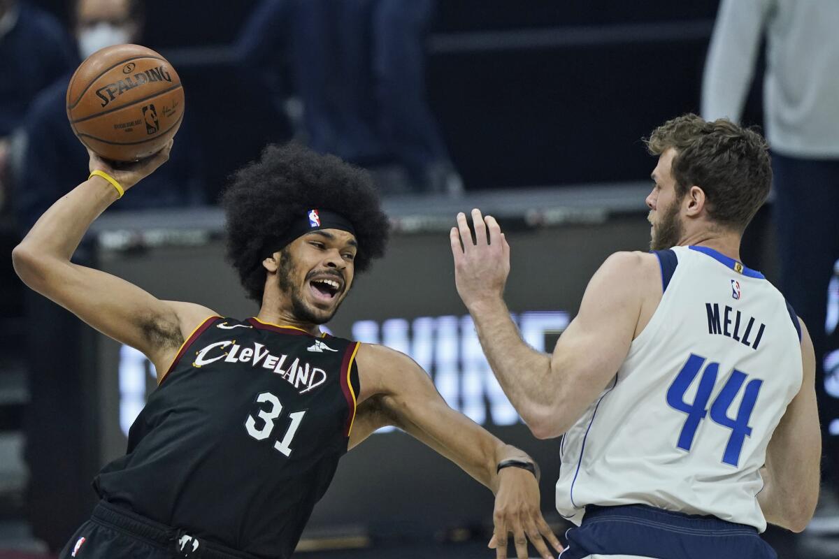 FILE - In this May 9, 2021, file photo, Cleveland Cavaliers' Jarrett Allen (31) tries to pass the ball against Dallas Mavericks' Nicolo Melli (44) in the first half of an NBA basketball game in Cleveland. The Cavaliers signed Allen to a five-year, $100 million contract on Friday, Aug. 6, 2021, securing the 23-year-old center as one of their foundational players. Allen, who came over in a mid-season deal from Brooklyn, was a restricted free agent before coming to terms with Cleveland earlier this week. (AP Photo/Tony Dejak, File)